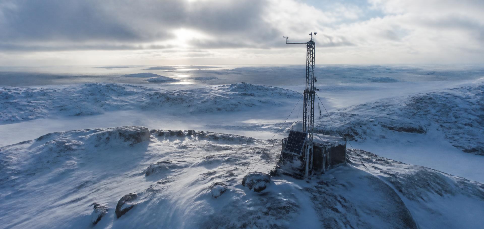 Hardened sensor mast on a snow-covered Arctic landscape