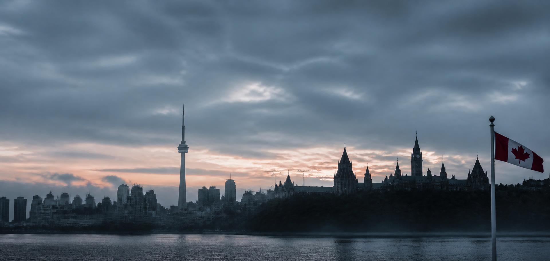 Canadian skyline at dusk with a Canadian flag